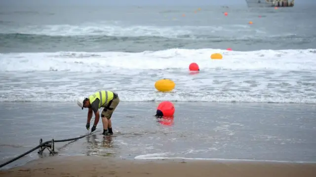 फ़ाइबर ऑप्टिक केबल पर काम करता एक ऑपरेटर