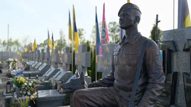 Военное кладбище под Ивано-Франковском. Статуя солдата с собакой на фоне ряда могил