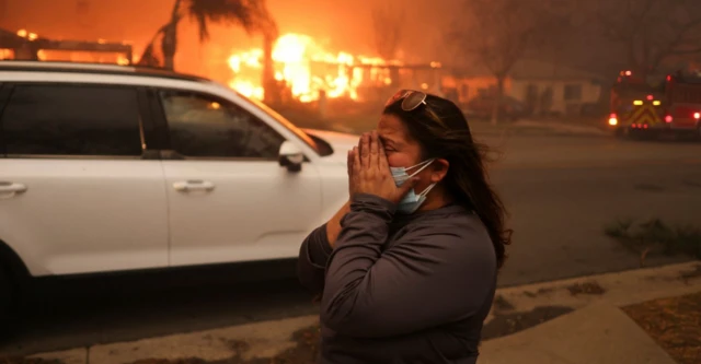 Los Angeles'ta evinden tahliye edilen bir kadın, Altadena'daki Eaton Yangını'na kaygılı gözlerle izliyor