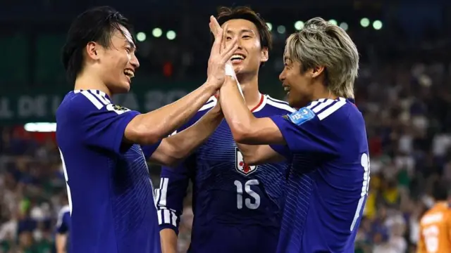 青色ユニホームを着た3選手が笑顔で集まっている。伊藤と上田は両手を合わせている
