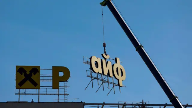 Démontage de l'enseigne de la banque Raiffeisen à Moscou.