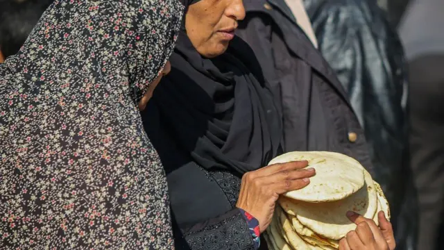 مواطنون نازحون يشترون الطعام والفواكه والخضروات اللازمة أثناء الحرب من السوق الشعبية في 1 يناير/كانون الثاني 2024 في رفح، غزة.