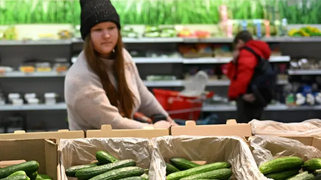 Supermarket w rosyjskim mieście Omsk. Młoda kobieta przygląda się pudełkom ogórków leżącym w rzędzie na półce. 17 lutego 2026 roku. Zdjęcie: Alexey Malgavko