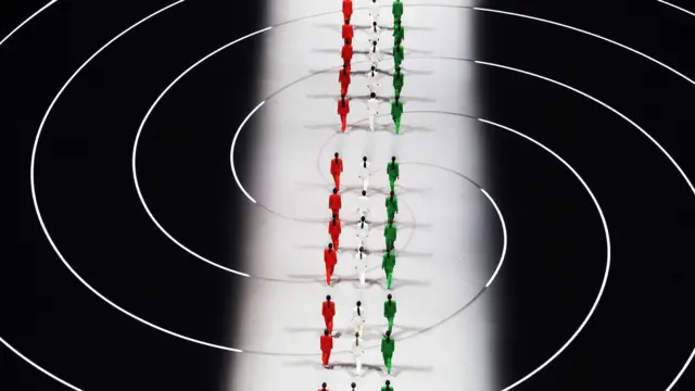 উদ্বোধনী অনুষ্ঠানে জর্জিও আরমানির ডিজাইন করা পোশাক পরা মডেলদের ছবি তোলা হয়েছে