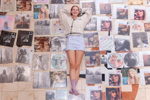 Фанатка Тейлор Свіфт позує зі своєю колекцією вінілових платівок