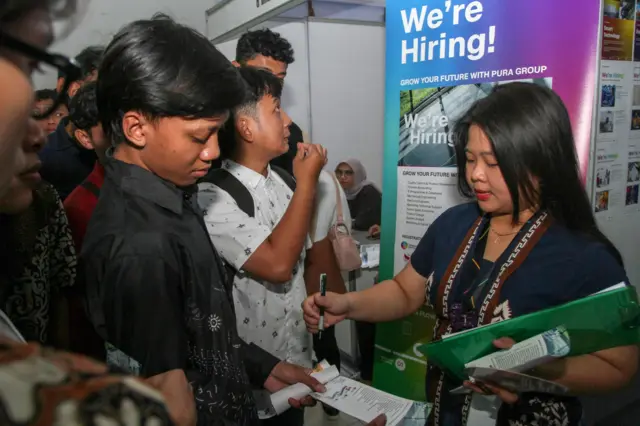 Petugas menjelaskan informasi lowongan pekerjaan kepada pencari pekerja saat Job Fair Kudus 2025 di Gedung Hraha Mustika, Desa Getas Pejaten, Kabupaten Kudus, Jawa Tengah, Jumat (10/10/2025). Pemerintah Kabupaten Kudus menggelar bursa kerja yang menghadirkan 20 perusahaan dengan total 1.401 lowongan pekerjaan bagi penyandang disibilitas, lulusan perguruan tinggi dan SMA sebagai upaya penyerapan tenaga kerja serta menekan angka pengangguran. 