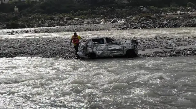 नदी किनारे एक दुर्घटनाग्रस्त हुई गाड़ी