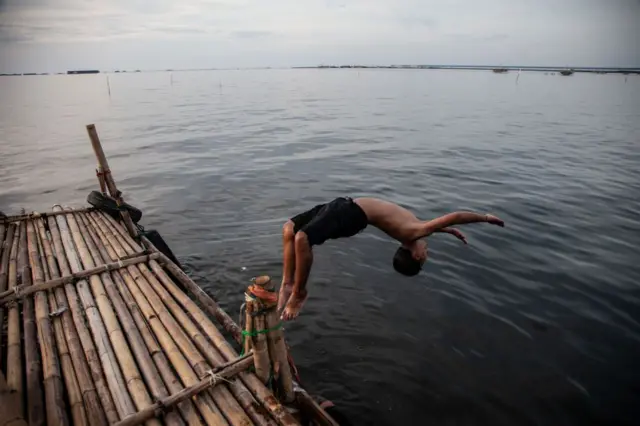 Salah seorang warga sedang berenang di Pantai Umum Marunda di pesisir utara Jakarta, Indonesia, pada 23 April 2024.