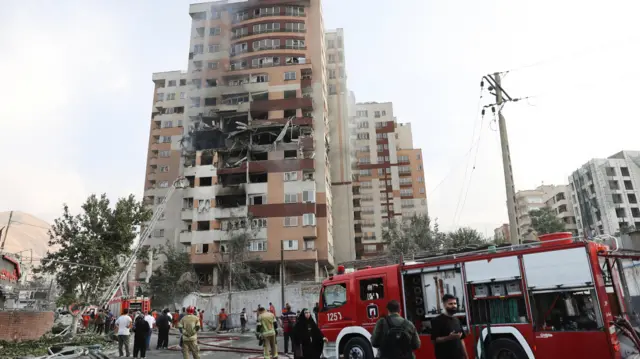 Bomberos trabajan en el lugar de un edificio dañado