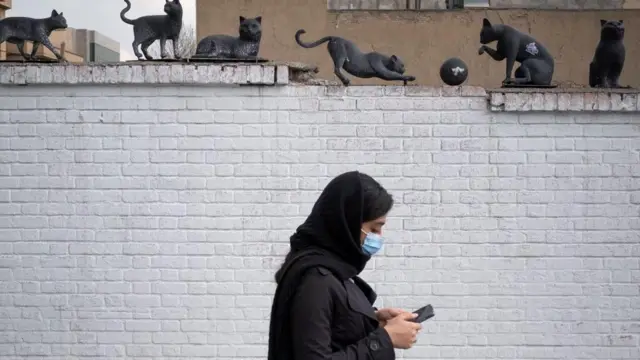 زنی موبایلش را در تهران چک می‌کند