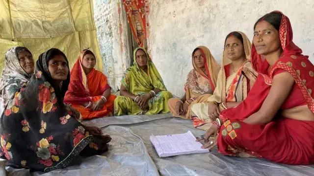 Usha Devi (à l'extrême droite) assise à côté de femmes de son groupe d'entraide