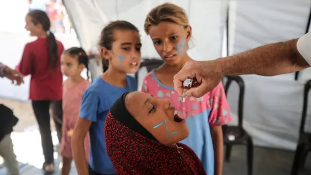 طفلة فلسطينية تتلقى مطعوماً ضد شلل الأطفال في غزة.