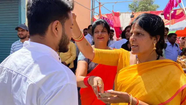 मंदिरात दर्शनासाठी येणाऱ्यांचं स्वागत करताना महिला भाविक.