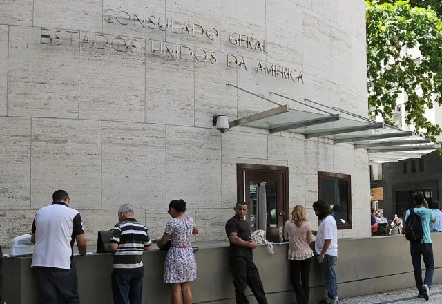Personas haciendo fila afuera de un consulado de Estados Unidos en Brasil.