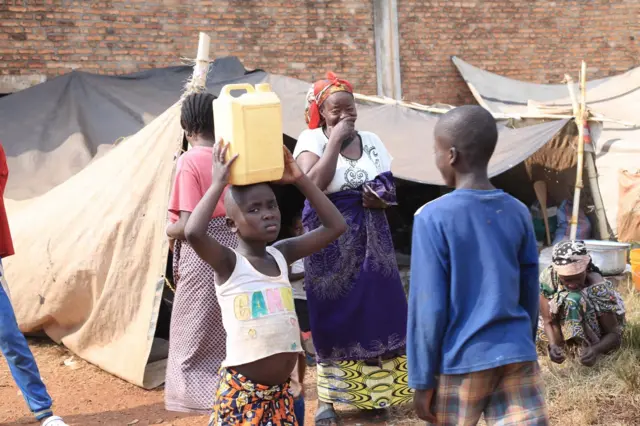Umwana w'impunzi avuye kuvoma ku kibuga c'umupira w'amaguru ca Rugombo mu ntara ya Cibitoke