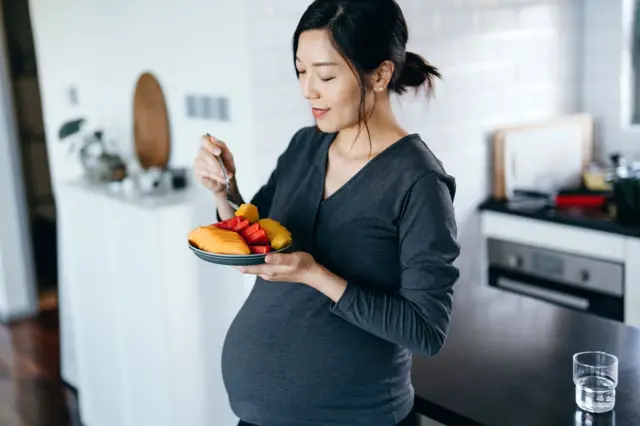 Ilustrasi ibu hamil makan makanan sehat.