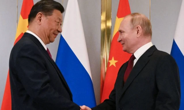 Xi Jinping e Vladimir Putin se cumprimentam