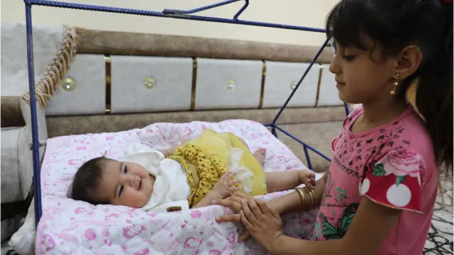 Baby Afraa on a swing her cousin dey attend to her