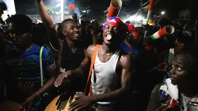 Torcedores em Porto Príncipe comemoram a qualificação do Haiti para a Copa do Mundo, um deles está batendo um tambor