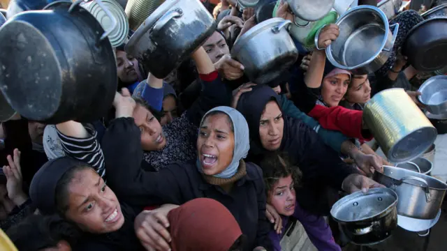 فلسطينيون يحاولون الحصول على طعام في ظل أزمة الغذاء التي يعيشها قطاع غزة جراء استمرار الحرب