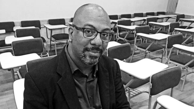 Adilson Moreira sorrindo contidamente, sentadovirtuais bet365salavirtuais bet365aula