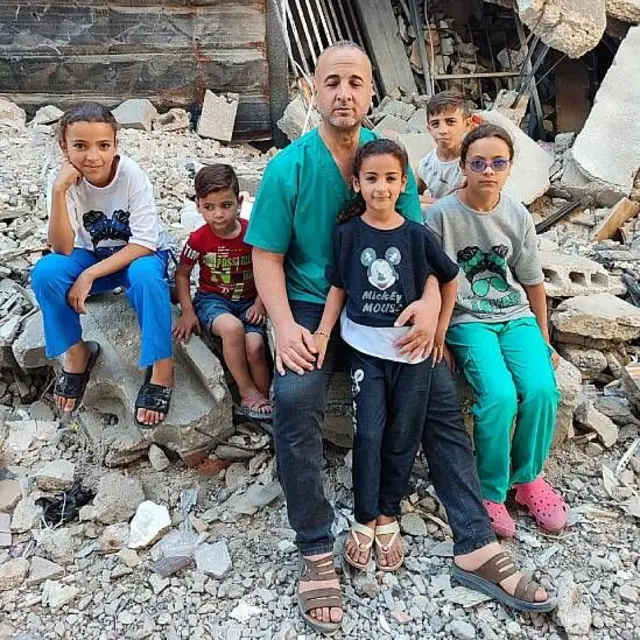 Alathamna y sus niños sentados entre ruinas