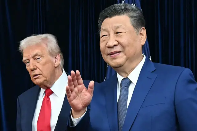 Xi Jinping, a la derecha, saluda sonriente, con Donald Trump, a su derecha en segundo plano. 
