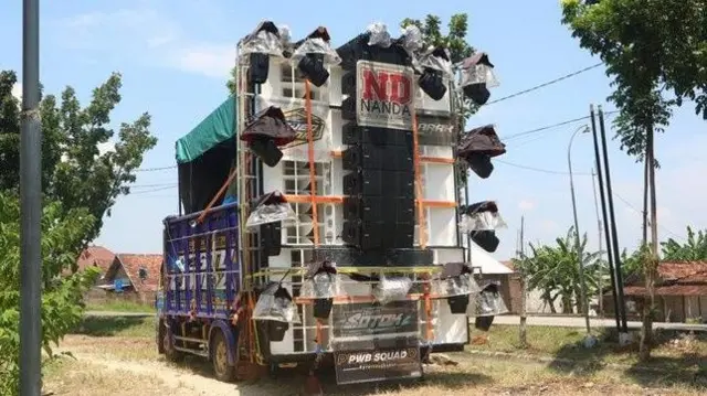 Truk terbuka mengangkut puluhan pengeras suara untuk menggelar musik horeg.