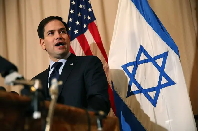 Marco Rubio frente a una bandera de EE.UU. y otra de Israel.