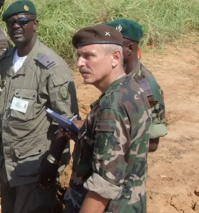 Мужчина в военной форме рядом с африканскими военными