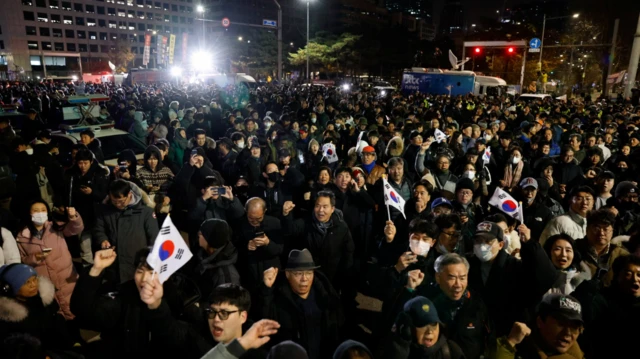 Una multitud de manifestantes frente al Parlamento de Corea del Sur clamó "No a la ley marcial" y levantó banderas del país.