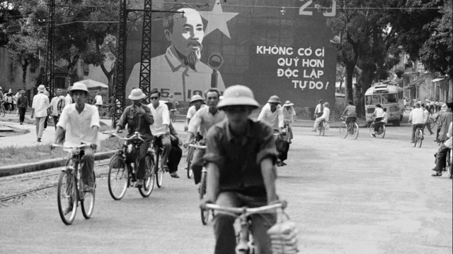 کارگران ویتنامی در شهر هو شی مین ویتنام کلاه به سر و سوار بر دوچرخه