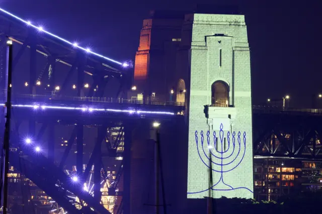 An image of a menorah is projected onto the pylons of the Sydney Harbour Bridge during New Year’s Eve celebrations on December 31, 2025, in Sydney, Australia.
