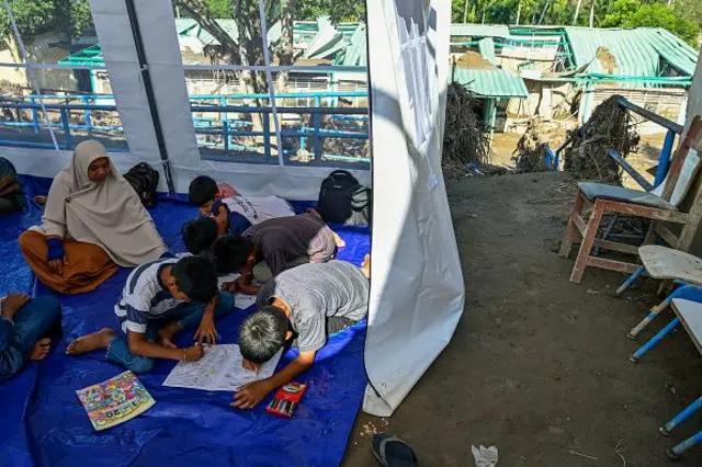 Siswa berkumpul di kelas darurat di dalam tempat penampungan setelah sekolah dasar mereka dihancurkan oleh banjir bandang di daerah yang berdekatan dengan Sungai Peusangan di distrik Bireuen, provinsi Aceh, Indonesia pada 5 Januari 2026