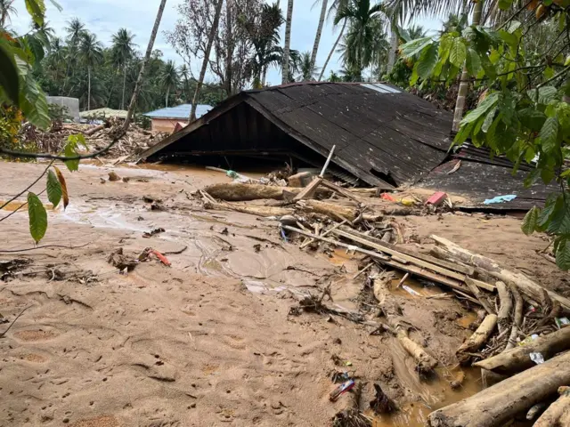 Sebuah rumah tampak atapnya saja setelah terkena banjir bandang di Sumatra Utara.