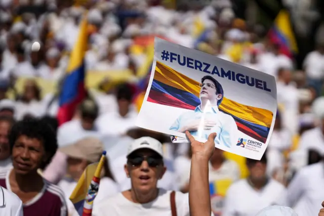 Personas con cartel de "Fuerza, Miguel" y banderas de Colombia.