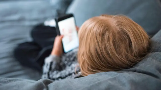 koltukta yatar halde elinde akıllı telefonlar bir kız çocuğu