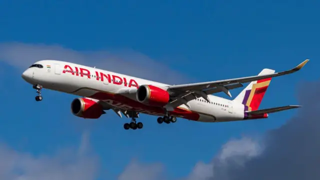 Un avión de Air India con las letras en rojo sobre blanco en pleno vuelo.