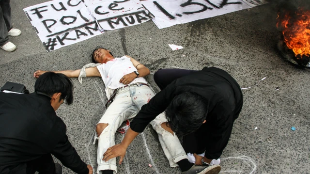 Pengunjuk rasa yang tergabung dalam Aliansi Barikade menampilkan aksi teatrikal penembakan warga sipil di depan Polda Kalteng, Palangkaraya, Kalimantan Tengah, Kamis (19/12/2024).