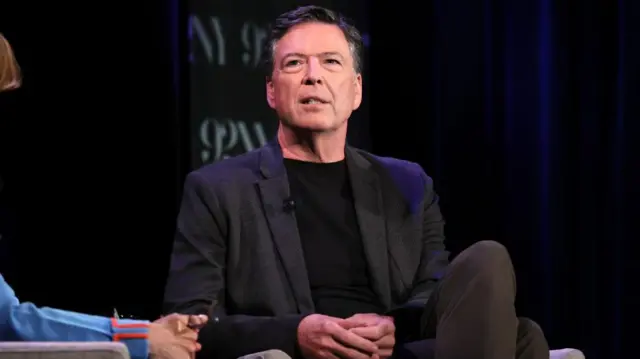 James Comey sentado, durante entrevista