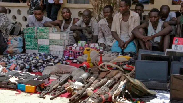 हथियारों के साथ बैठे हुए गिरफ़्तार गिरोह सदस्य