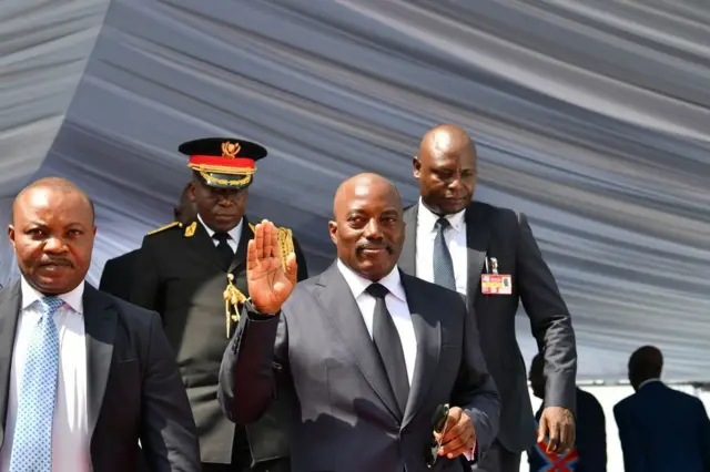 Le président sortant de la République démocratique du Congo, Joseph Kabila salue en quittant le podium le 24 janvier 2019 après avoir officiellement remis les instruments du pouvoir au président nouvellement investi à la présidence à Kinshasa. - 