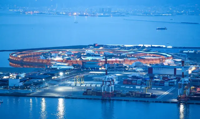An aerial picture showing a dockside and a large wooden ring structure.