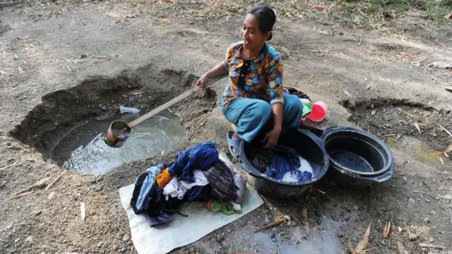 Seorang perempuan mencuci baju dari lubang yang digali dekat sungai di Grobogan, Jawa Tengah, September 2023. Kegiatan ini dilakukan lantaran sungai-sungai di kawasan itu telah mengering.