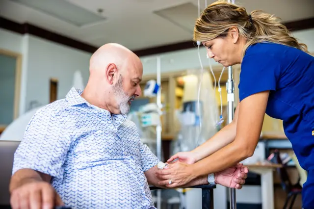 Un paciente recibe un tratamiento de quimioterapia de una enfermera