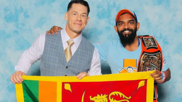 "පස්සේ මම ඔහුට ඉංග්රීසීයෙන් කිව්වා 'මම ශ්රී ලංකාවේ. අපේ රටේ ජාතික ධජයත් එක්ක ෆොටෝ එකකට පෙනී ඉන්න පුලුවන්ද කියලා. ජෝන් සීනා එකට කැමති වුණා."