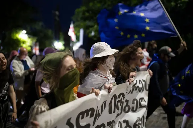 Девушки с плакатами на акции протеста на проспекте Руставели в Тбилиси