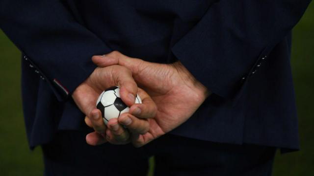 عکس کارلوس کی‌روش که توپ فوتبال کوچکی را در دست گرفته است