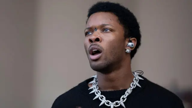 D4vd із відкритим ротом, у намисті у вигляді ланцюга