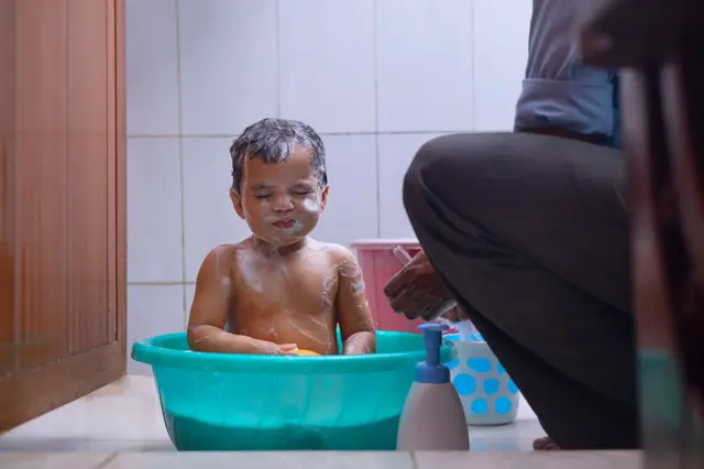 Portrait of little child having bath in bath tub